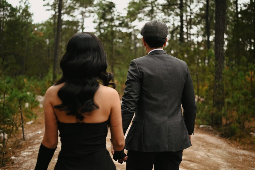 Couple walking hand-in-hand in a forest