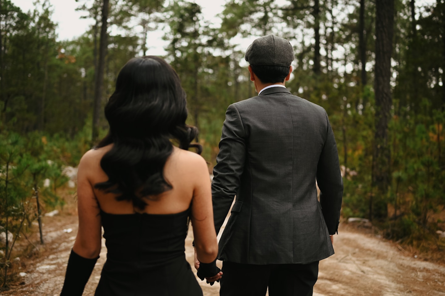 Couple walking hand-in-hand in a forest